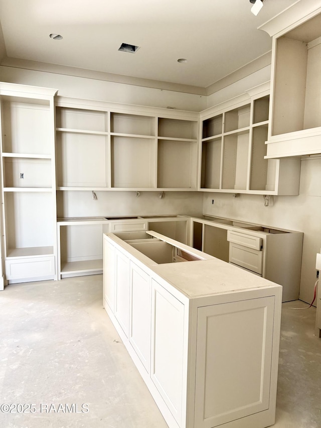 kitchen with unfinished concrete flooring and a center island