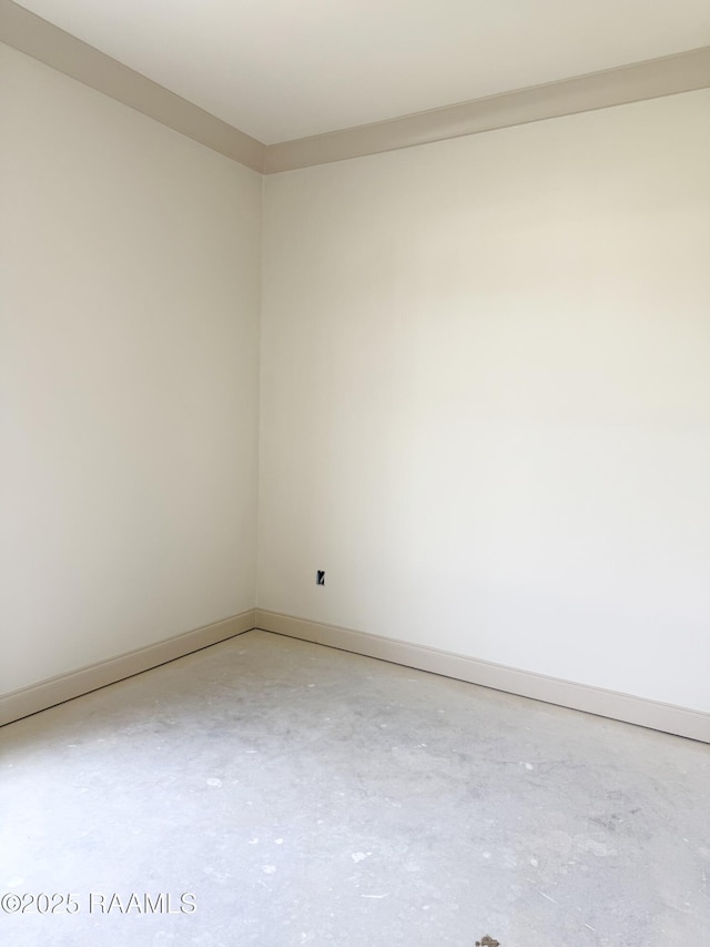 empty room with concrete flooring and baseboards