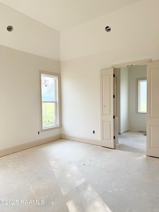 empty room with a wealth of natural light and baseboards