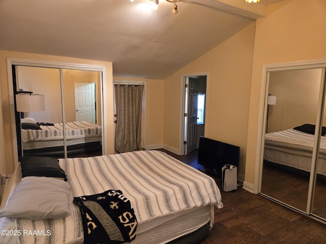 bedroom with lofted ceiling, dark wood-type flooring, a closet, and baseboards