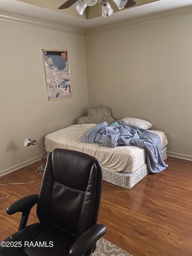 bedroom featuring ceiling fan, crown molding, baseboards, and wood finished floors