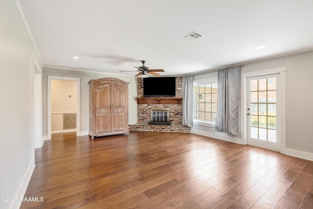 unfurnished living room featuring visible vents, a brick fireplace, a ceiling fan, and hardwood / wood-style flooring