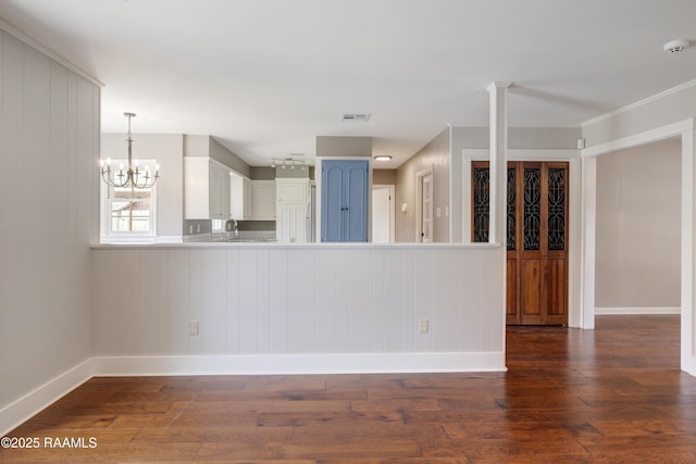 unfurnished living room featuring visible vents, a sink, dark wood finished floors, an inviting chandelier, and baseboards