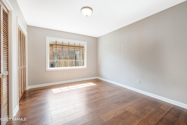 unfurnished bedroom with a closet, baseboards, and wood finished floors