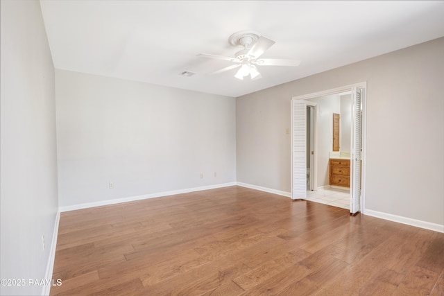 empty room featuring visible vents, light wood-style floors, baseboards, and ceiling fan