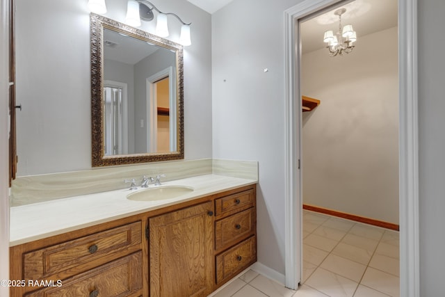 bathroom featuring visible vents, a notable chandelier, tile patterned flooring, baseboards, and vanity