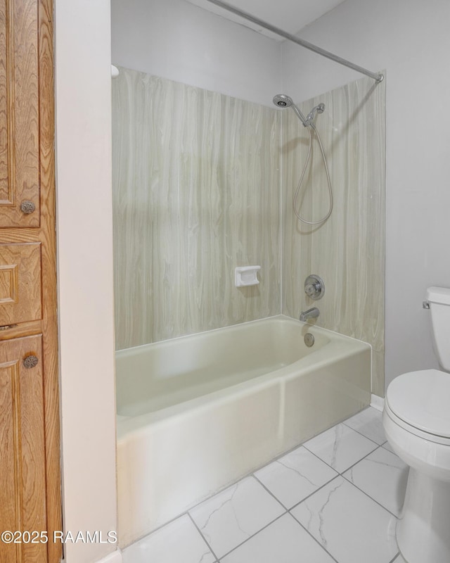 bathroom featuring shower / bathing tub combination, toilet, and marble finish floor