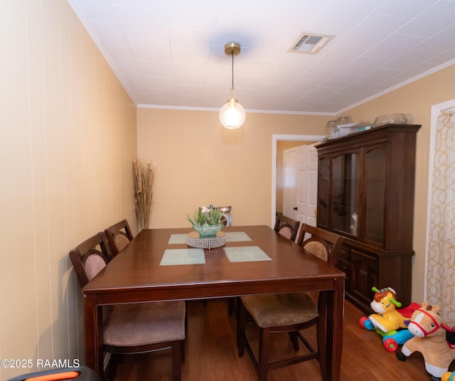 dining area with visible vents, wood finished floors, and ornamental molding