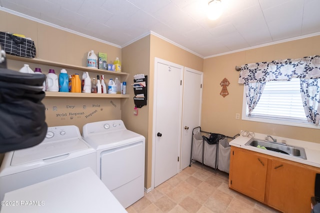 washroom featuring ornamental molding, independent washer and dryer, a sink, and cabinet space