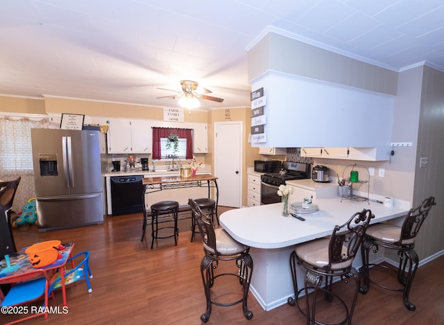 kitchen featuring a kitchen breakfast bar, dark wood-type flooring, a peninsula, light countertops, and black appliances