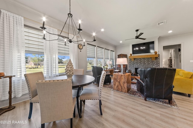 dining room with visible vents, crown molding, and light wood-style flooring