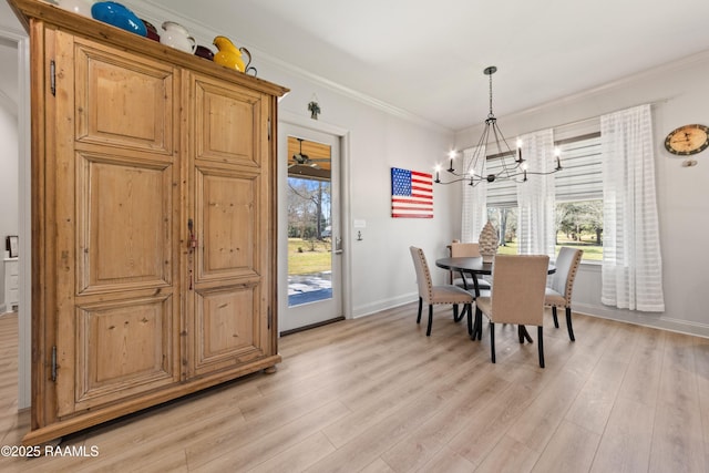 dining room with ornamental molding, light wood-style flooring, and baseboards