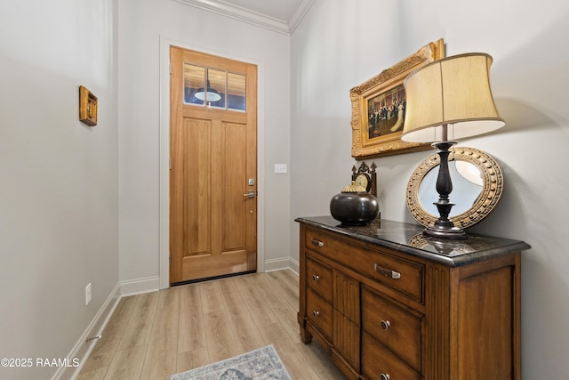 entryway with ornamental molding, light wood-style flooring, and baseboards