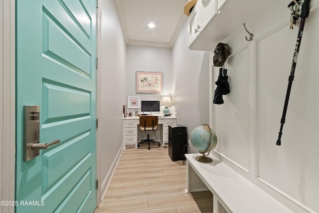 mudroom featuring wood finish floors, crown molding, and baseboards