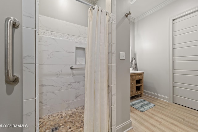 full bathroom with ornamental molding, a stall shower, wood finished floors, and baseboards