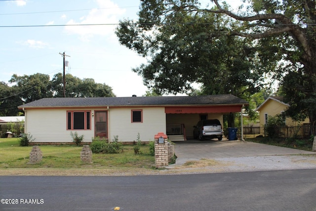 ranch-style house with driveway, a front lawn, fence, and an attached carport