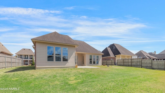 rear view of property featuring a fenced backyard, a lawn, and a patio