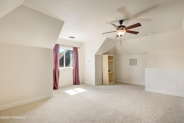 additional living space with lofted ceiling, visible vents, light carpet, and baseboards