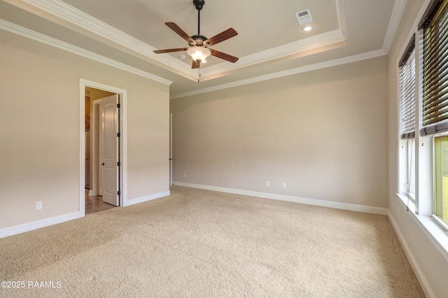 spare room featuring carpet floors, a raised ceiling, visible vents, and baseboards