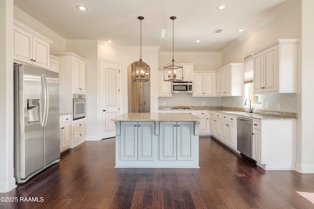 kitchen with dark wood-type flooring, a sink, a kitchen island, visible vents, and appliances with stainless steel finishes