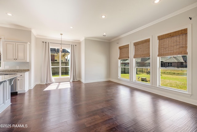 unfurnished living room featuring baseboards, dark wood finished floors, a notable chandelier, and recessed lighting