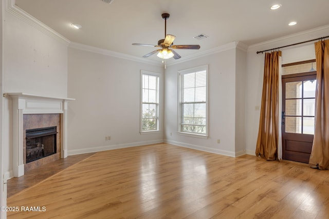 unfurnished living room with a fireplace, visible vents, crown molding, and light wood finished floors