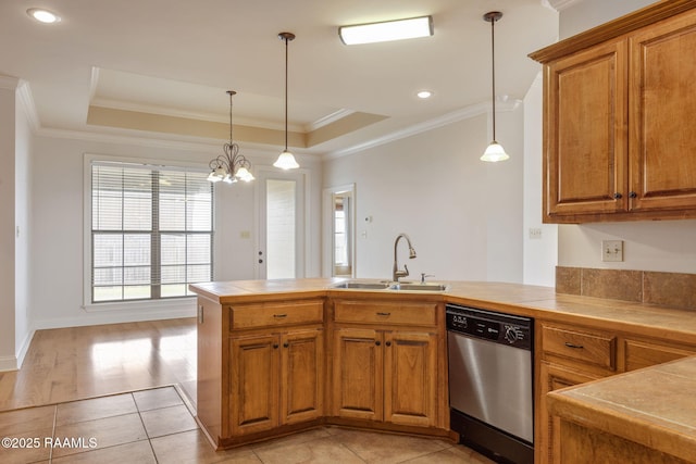 kitchen featuring a tray ceiling, pendant lighting, stainless steel dishwasher, a sink, and a peninsula