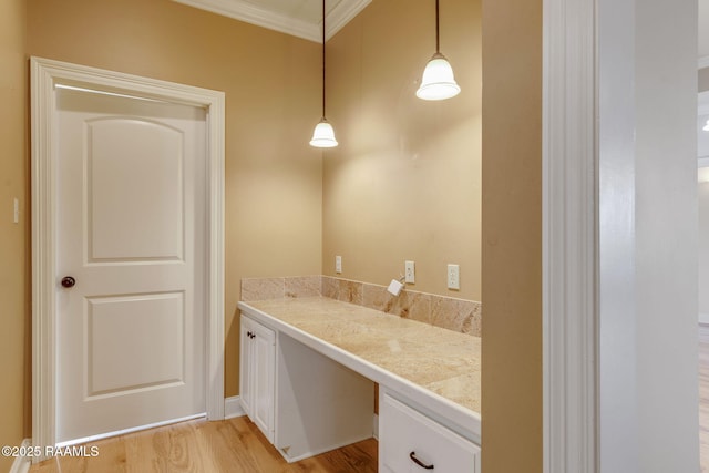 bathroom with ornamental molding, vanity, and wood finished floors