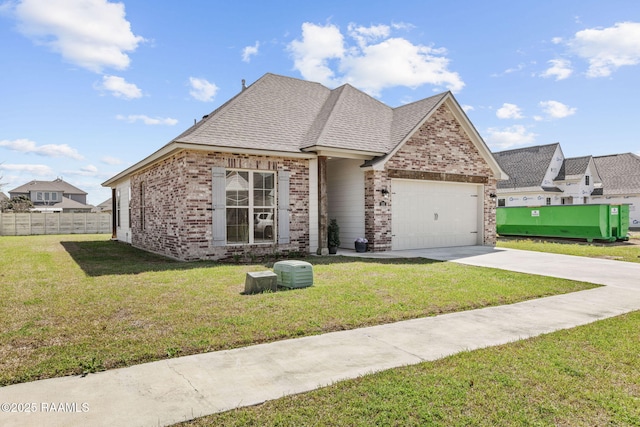 view of front of home with a front yard, fence, driveway, a garage, and brick siding