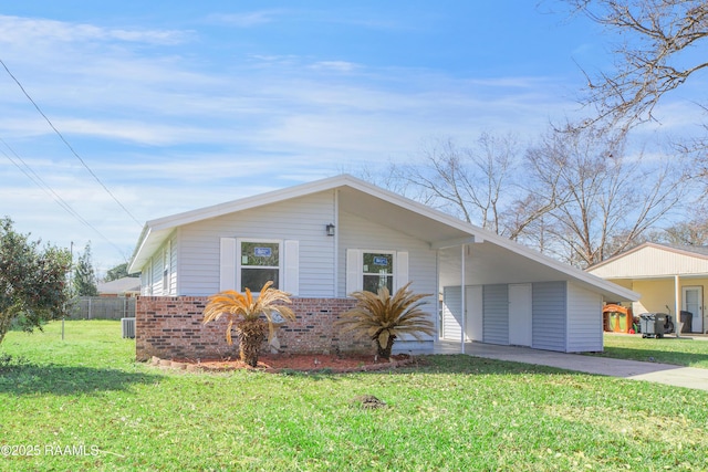 view of front of property with fence, a front lawn, an attached carport, and concrete driveway