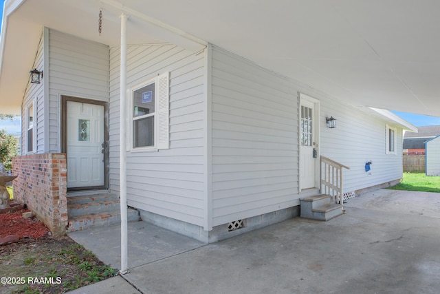 view of exterior entry with crawl space and a patio area