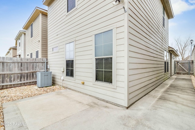 rear view of property featuring a patio area, fence, and central AC unit