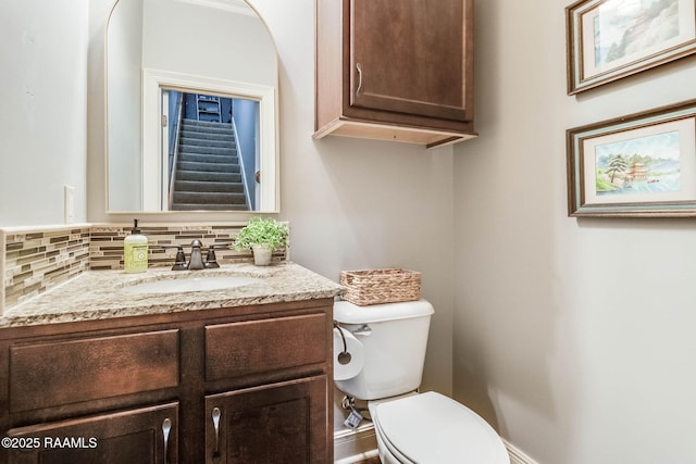 bathroom with toilet, decorative backsplash, and vanity