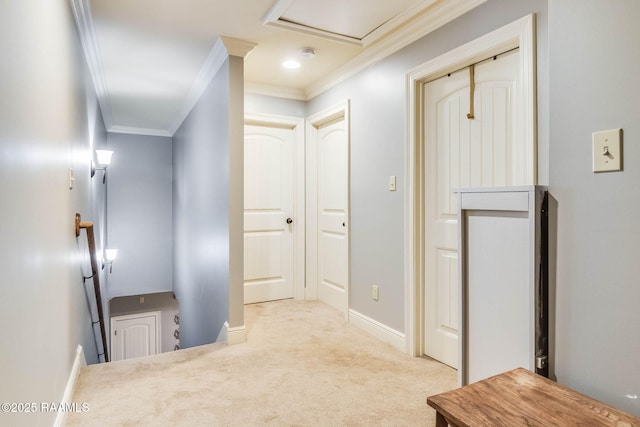 hall featuring attic access, baseboards, ornamental molding, carpet flooring, and an upstairs landing