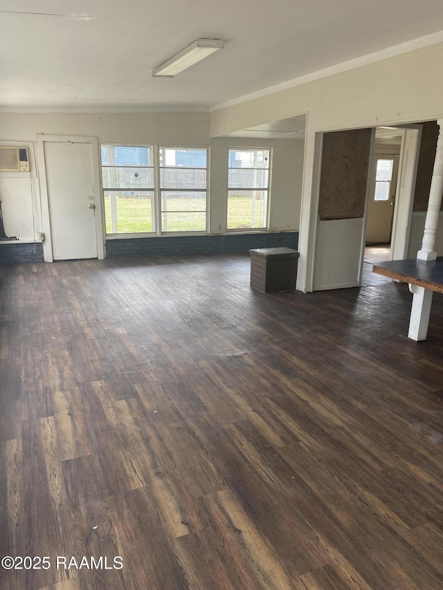 unfurnished living room with dark wood-style floors and ornamental molding