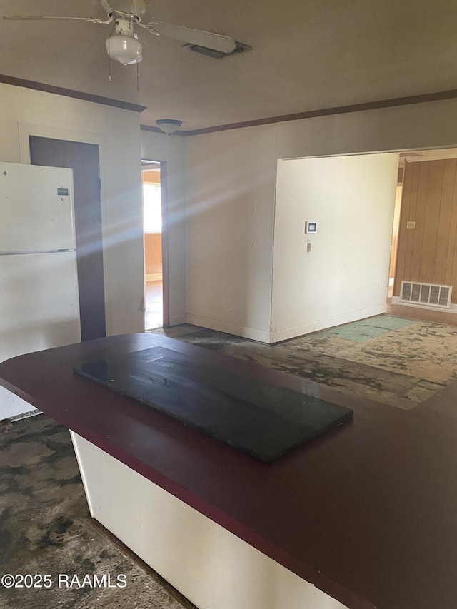 interior space featuring freestanding refrigerator, visible vents, and a ceiling fan