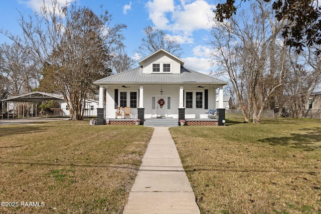 bungalow-style house featuring a porch, a ceiling fan, a front lawn, and metal roof