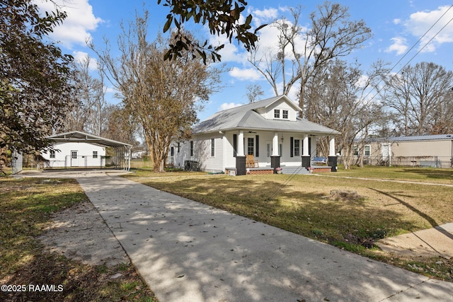 bungalow-style house featuring a front yard, covered porch, and metal roof