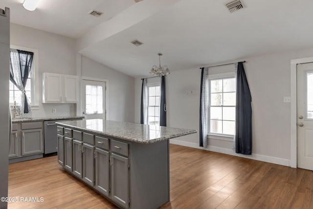 kitchen featuring visible vents, stainless steel dishwasher, and gray cabinets