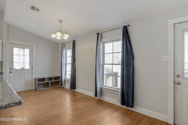 foyer with a wealth of natural light, visible vents, and light wood-style flooring