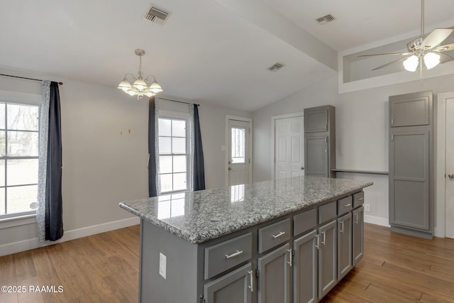 kitchen with wood finished floors, visible vents, gray cabinets, and vaulted ceiling