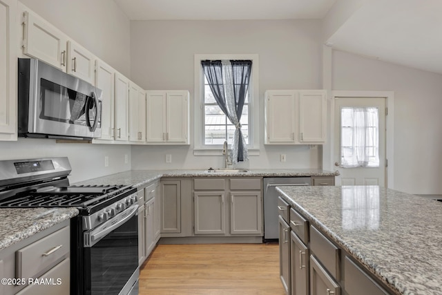 kitchen featuring a wealth of natural light, stainless steel appliances, light wood-type flooring, and a sink