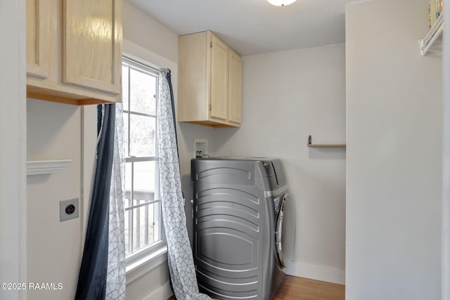 laundry room featuring cabinet space, wood finished floors, baseboards, and washer hookup