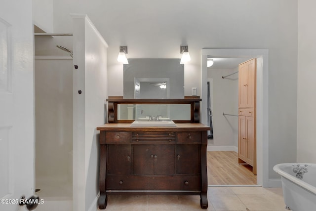 full bathroom with tile patterned flooring, baseboards, a soaking tub, walk in shower, and vanity