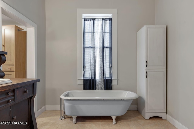 bathroom featuring tile patterned floors, a freestanding bath, vanity, and baseboards