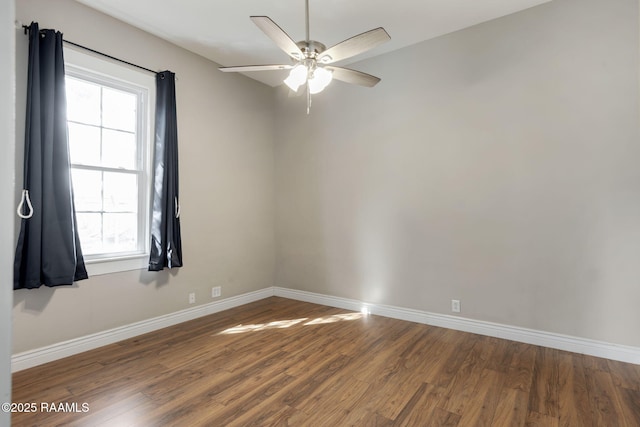 empty room featuring a ceiling fan, wood finished floors, and baseboards