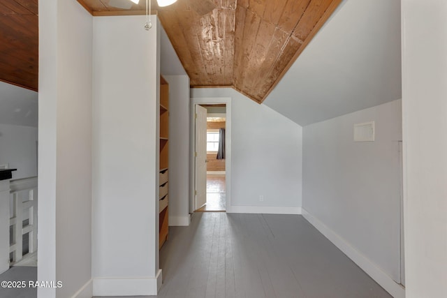 additional living space with baseboards, wood ceiling, wood-type flooring, and vaulted ceiling