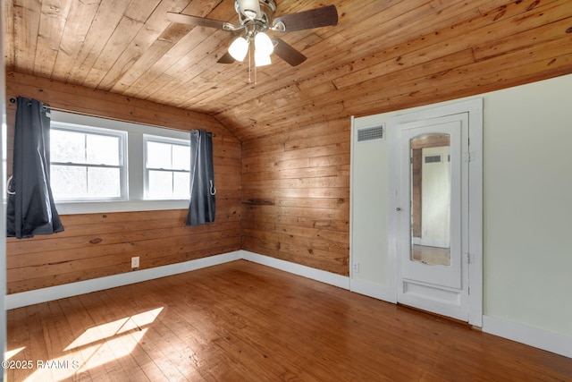 spare room with visible vents, baseboards, lofted ceiling, hardwood / wood-style floors, and wooden ceiling