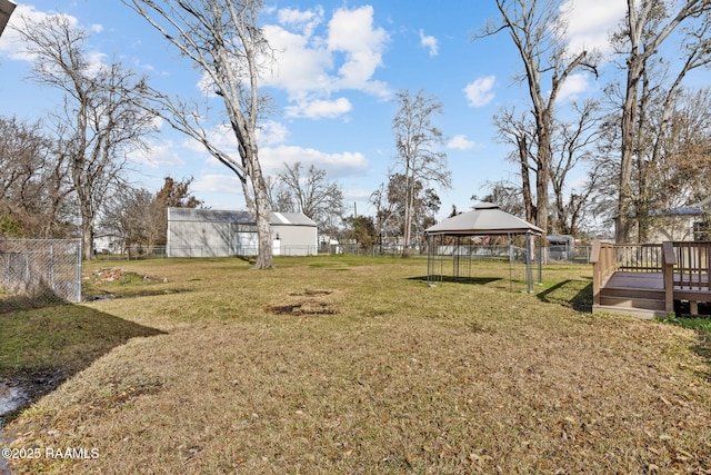 view of yard featuring a gazebo, a deck, and fence