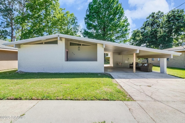 mid-century modern home featuring a carport, brick siding, a front lawn, and aphalt driveway